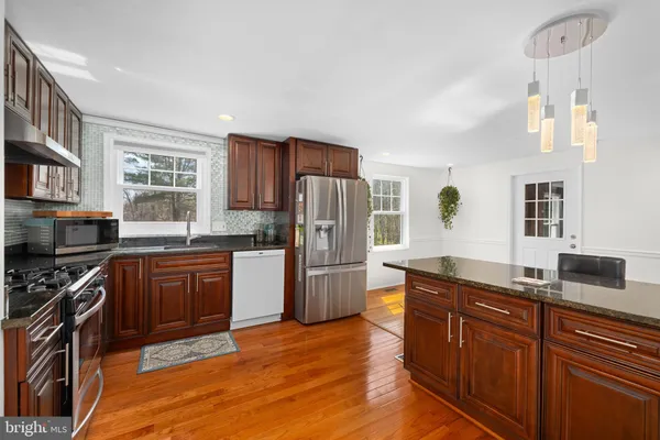 a kitchen with stainless steel appliances granite countertop a stove a sink dishwasher a refrigerator and a oven