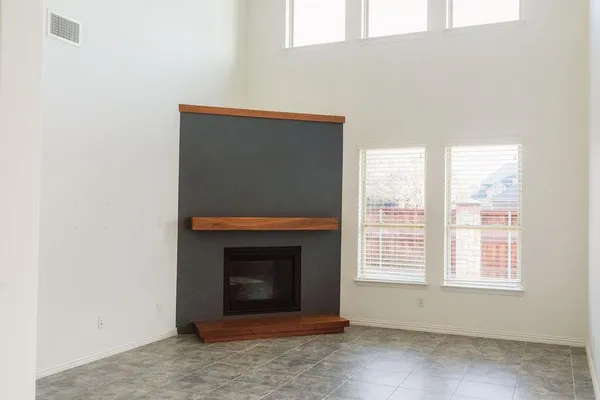 a living room with a fireplace and a floor to ceiling window