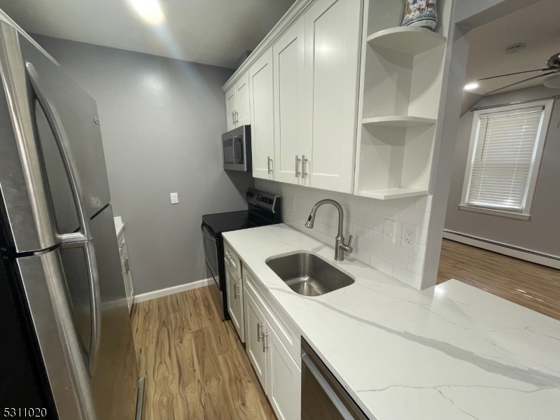 31 Union Street Dover, NJ 07801 - Photo 8 of 15 a kitchen with a sink a refrigerator and cabinets