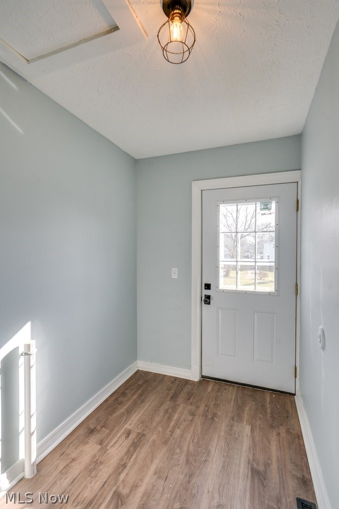 12 South 4th Street Rittman, OH 44270 - Photo 19 of 48 Doorway featuring wood finished floors and a textured ceiling