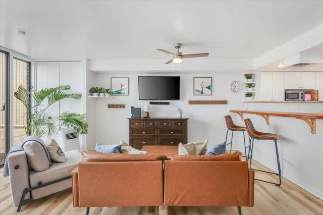 a living room with furniture a flat screen tv and a table