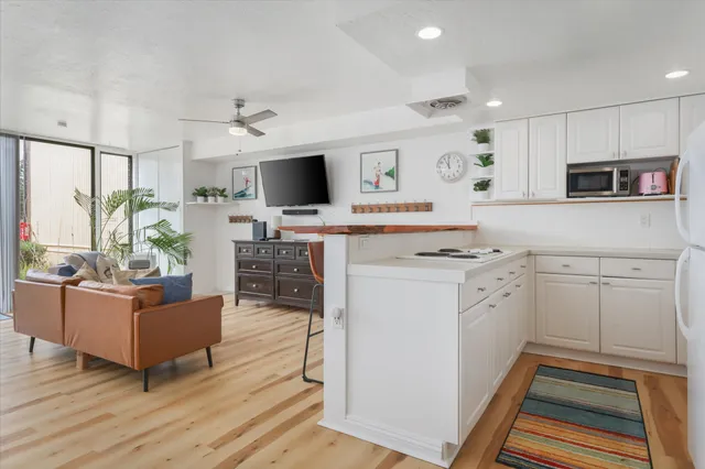 a kitchen with kitchen island white cabinets and stainless steel appliances