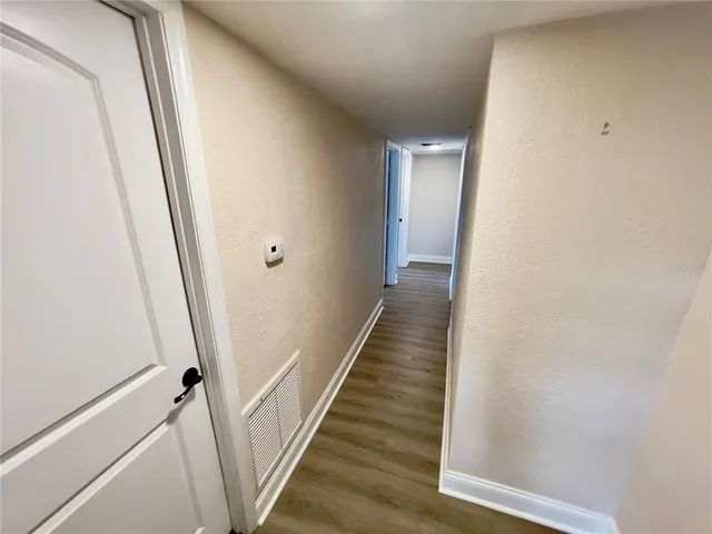 a view of a hallway with wooden floor