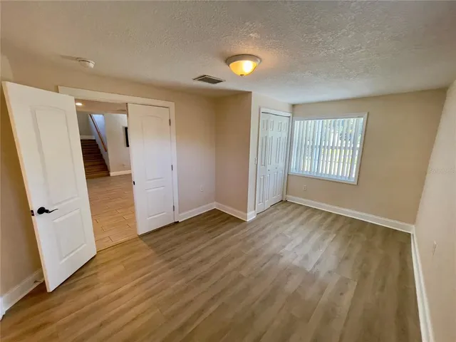an empty room with wooden floor and a window