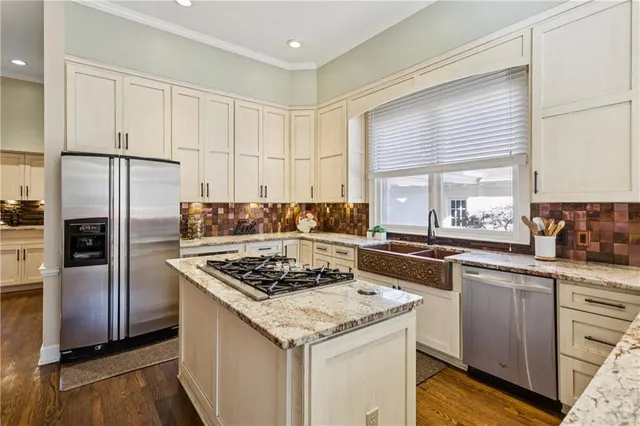 a kitchen with stainless steel appliances granite countertop a sink stove and refrigerator