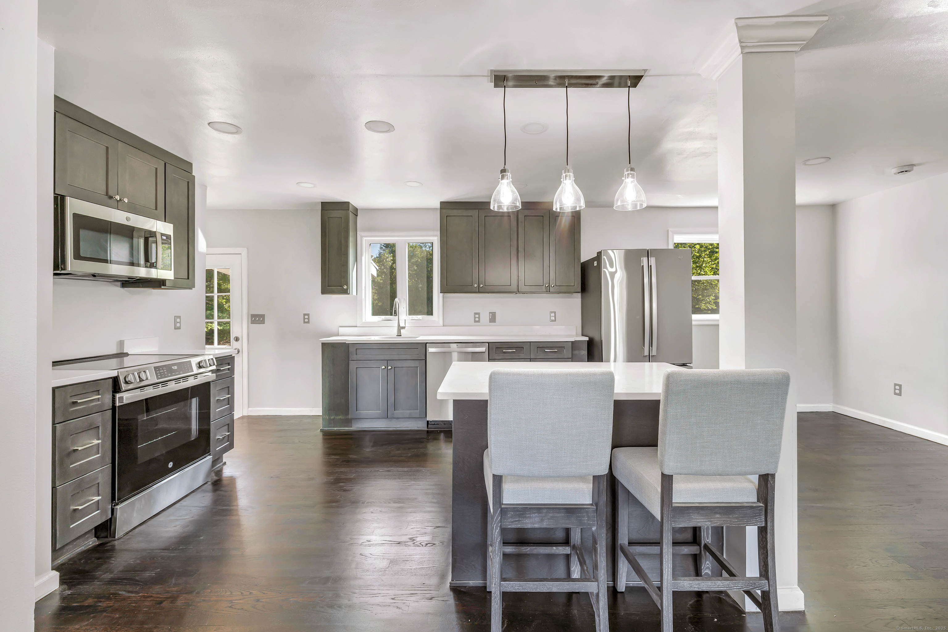 38 Pine River Road North Haven, CT 06473 - Photo 18 of 38 a kitchen with kitchen island granite countertop a stove a oven a dining table and chairs with wooden floor
