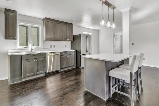a kitchen with a table chairs refrigerator and microwave