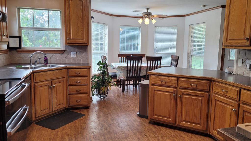 3164 Clater Powell Road Waco, TX 76705 - Photo 21 of 40 a kitchen with stainless steel appliances granite countertop a stove a sink dishwasher and a microwave oven with cabinets