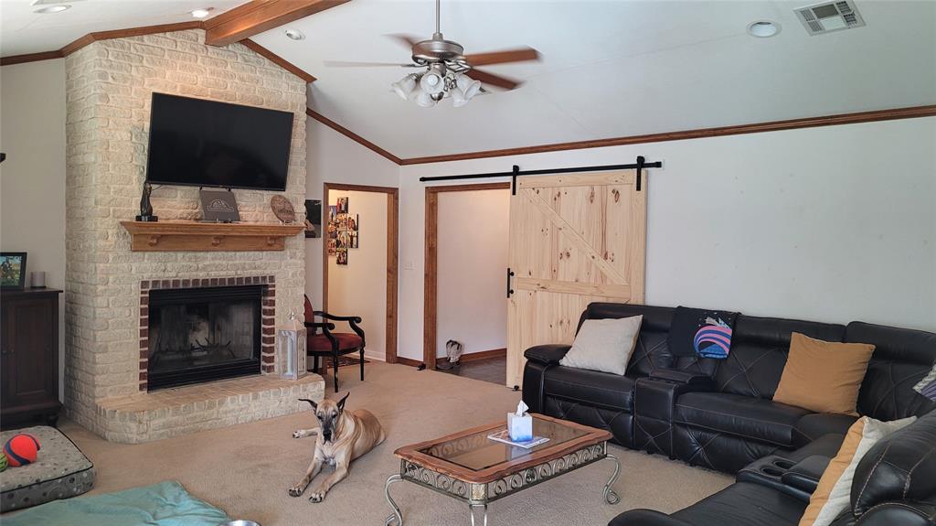 3164 Clater Powell Road Waco, TX 76705 - Photo 24 of 40 a living room with furniture a flat screen tv and a fireplace
