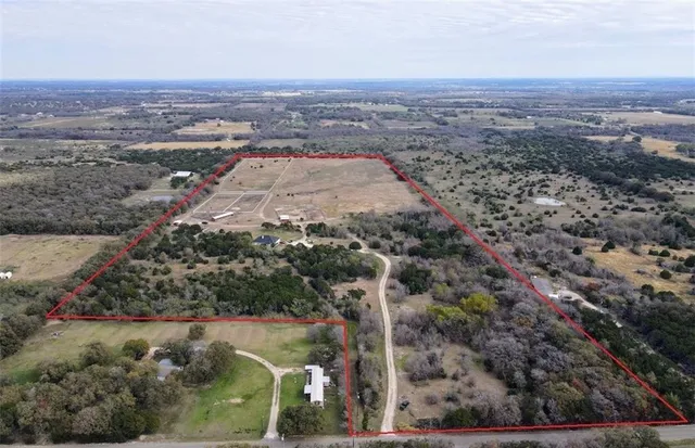 an aerial view of a house with a yard and lake view