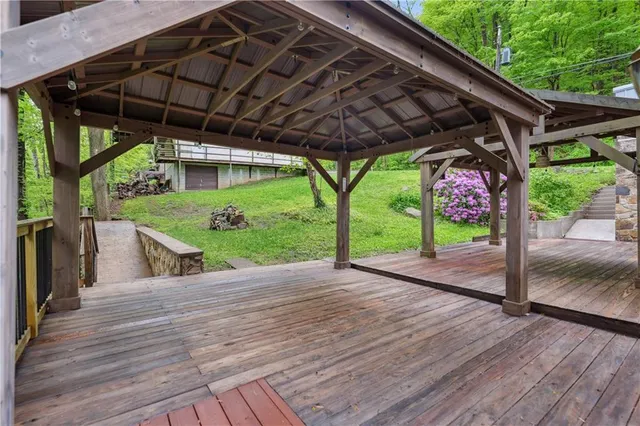 a view of a patio with table and chairs under an umbrella with a small yard