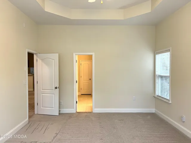 an empty room with windows and bathroom view