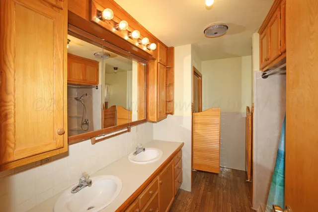 a bathroom with a double vanity sink a mirror and a shower