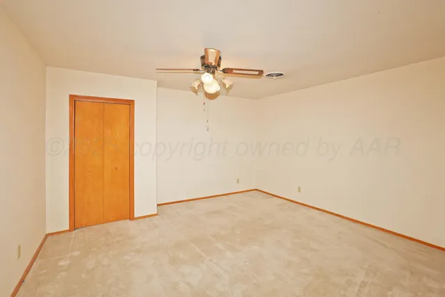 a view of a small space with wooden floor and a ceiling fan