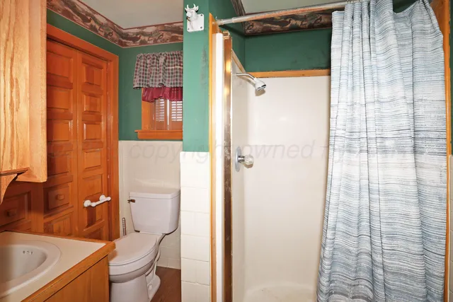 a bathroom with a toilet and a shower