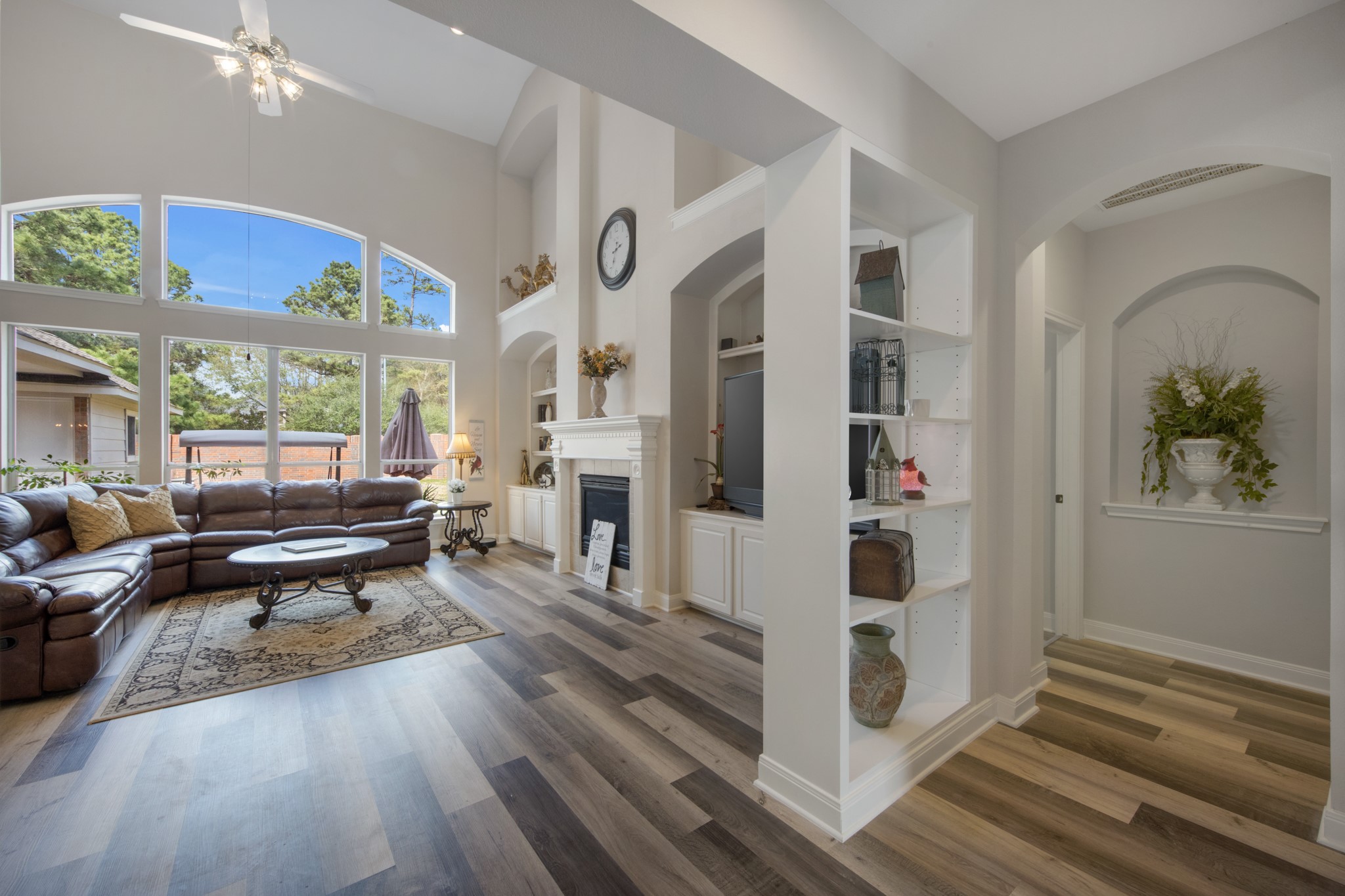 9510 Ashdown Forest Drive Spring, TX 77379 - Photo 18 of 50 LIVING ROOM – spacious living area featuring a beautiful fireplace, custom built-ins, and large windows that bring the outdoors inside. Perfect for relaxing or entertaining.