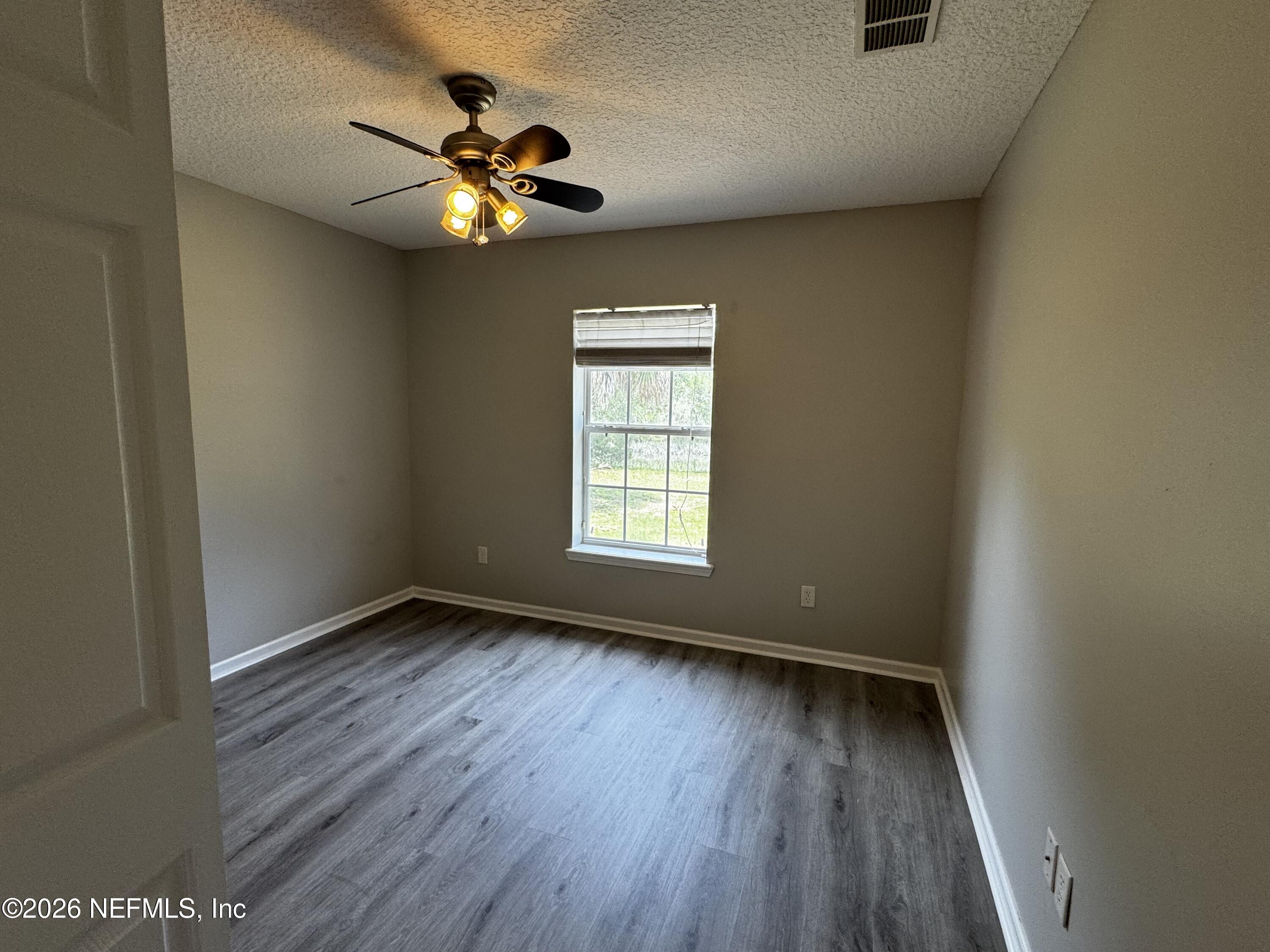 16255 Shellcracker Road Jacksonville, FL 32226 - Photo 28 of 40 a view of an empty room with wooden floor and a window