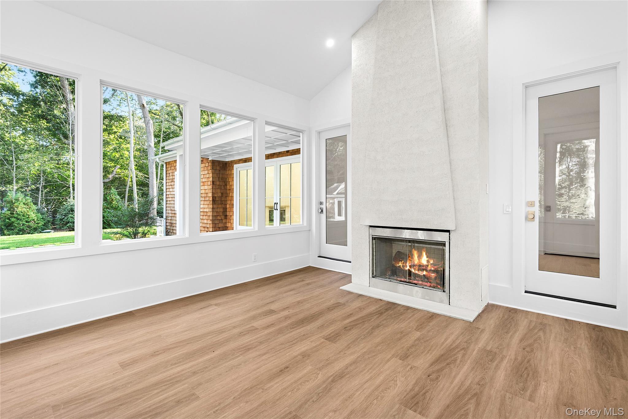 5697 Westphalia Road Mattituck, NY 11952 - Photo 13 of 28 an empty room with wooden floor fireplace and windows