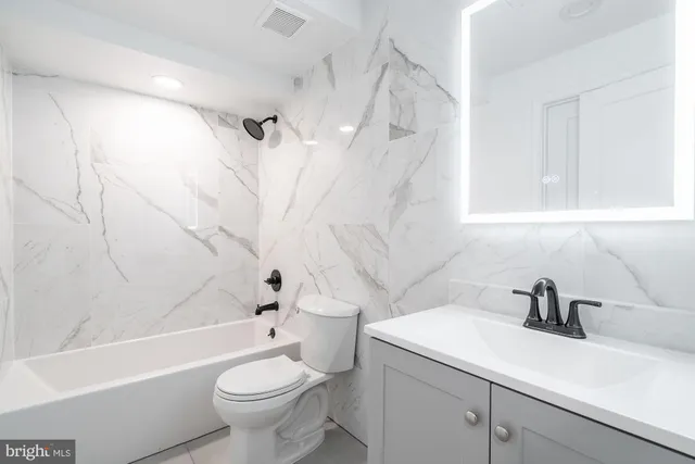 a bathroom with a sink a toilet and a shower