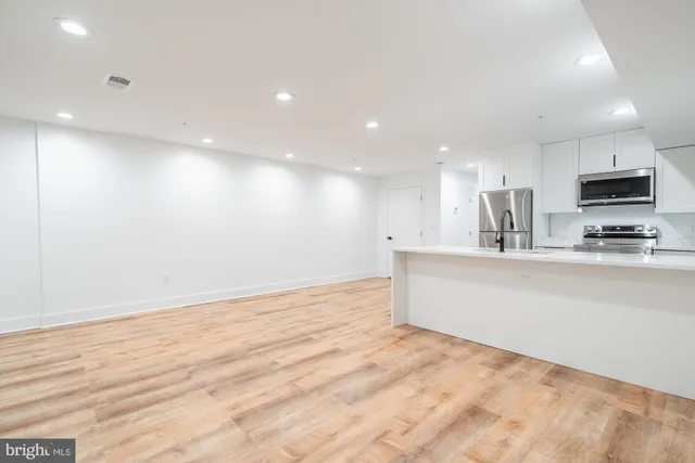 a view of a kitchen with a sink and a refrigerator