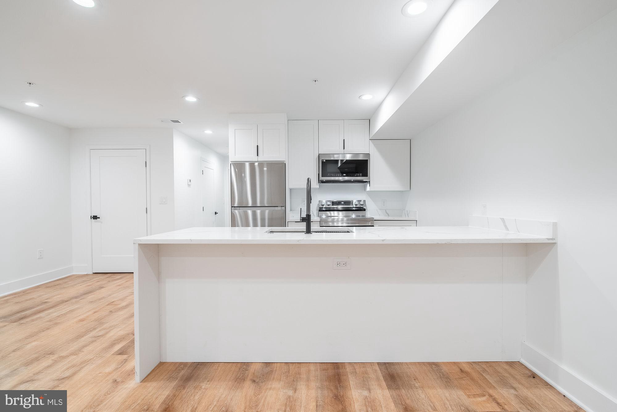 36 Channing Street Northwest, Unit A Washington, DC 20001 - Photo 4 of 33 a kitchen with kitchen island a sink stainless steel appliances and cabinets