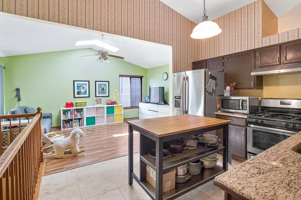 a kitchen with stainless steel appliances a stove a refrigerator and a dining table
