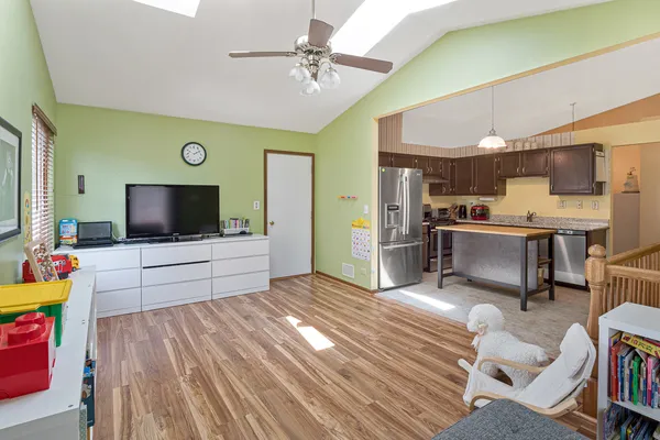 a living room with stainless steel appliances furniture and a flat screen tv