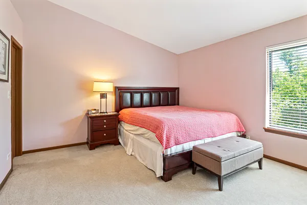 a spacious bedroom with a bed and a window