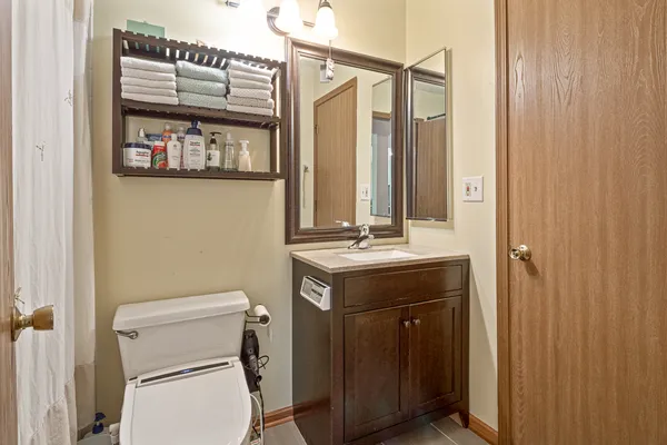 a bathroom with a sink a toilet and shower