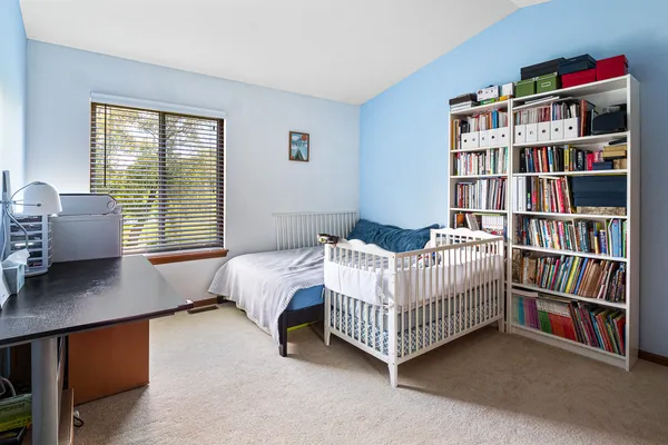 a bedroom with a bed and a book shelf