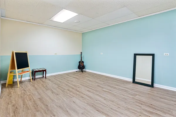 a view of a livingroom with wooden floor and a workspace