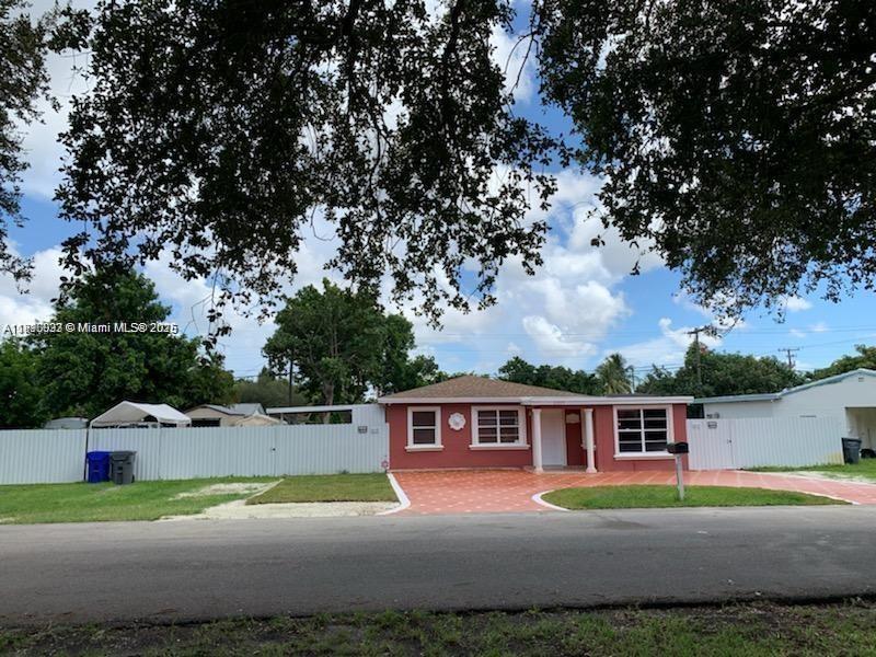 6309 Wiley Street Hollywood, FL 33023 - Photo 1 of 9 a front view of a house with a yard and garage