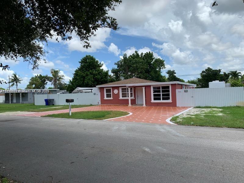 6309 Wiley Street Hollywood, FL 33023 - Photo 2 of 9 a front view of a house with a yard and garage
