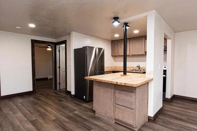 a kitchen with stainless steel appliances granite countertop a sink and a refrigerator