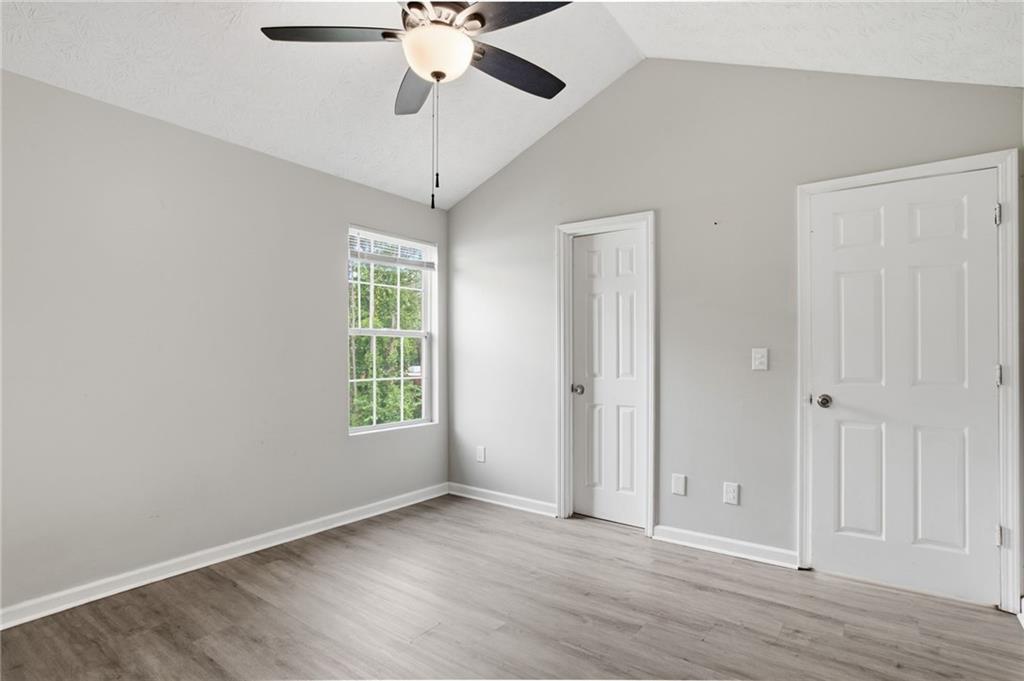 5855 Crescent Ridge Court Lithonia, GA 30058 - Photo 21 of 46 an empty room with wooden floor chandelier fan and windows