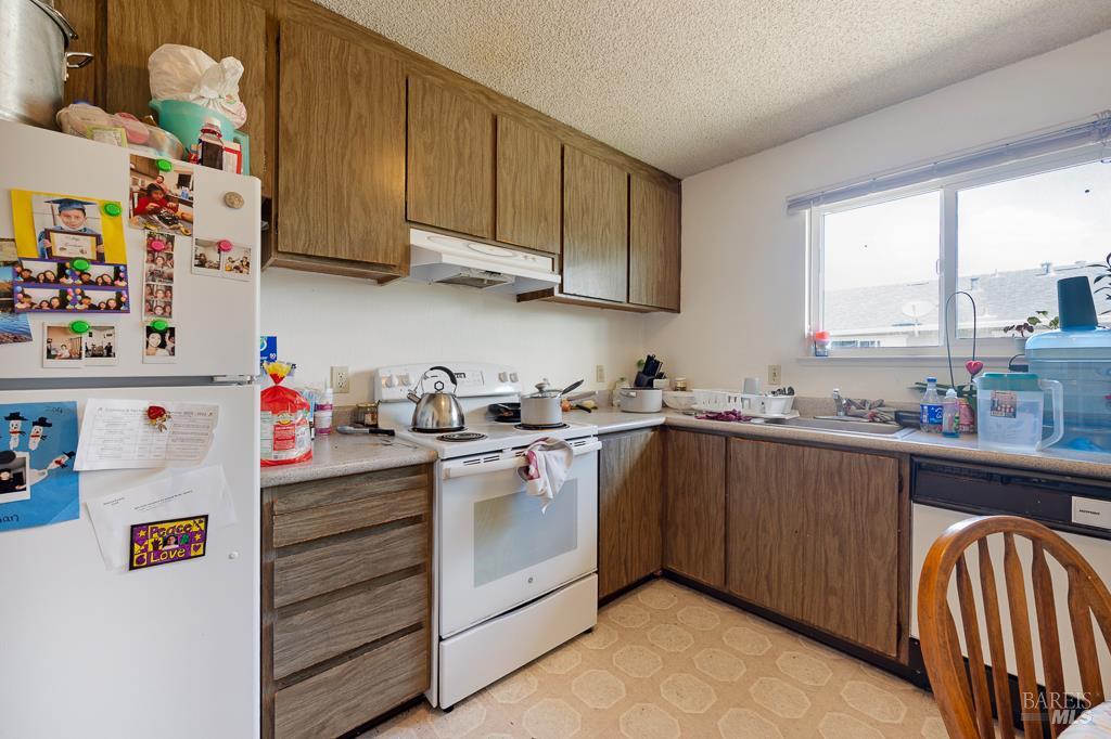 2313 Heidi Place Santa Rosa, CA 95403 - Photo 14 of 14 a kitchen with stainless steel appliances granite countertop a sink and dishwasher a refrigerator with wooden cabinets