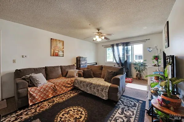 a living room with furniture a chandelier and a flat screen tv