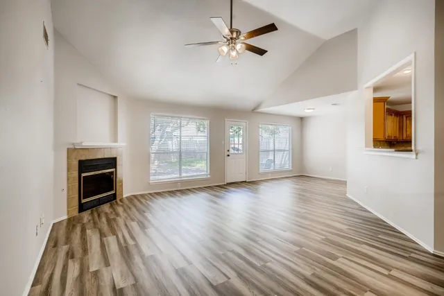 a view of an empty room with a fireplace and a window