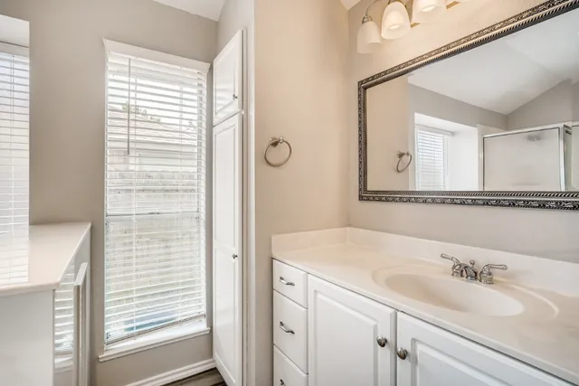 a bathroom with a granite countertop sink and a mirror