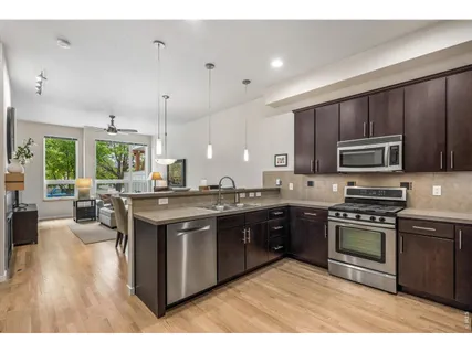 a kitchen with stainless steel appliances granite countertop a stove a sink dishwasher a microwave oven and a refrigerator