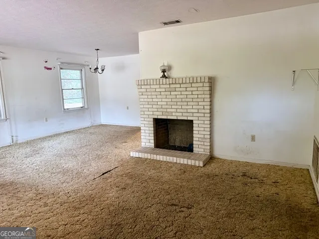 a view of empty room with kitchen
