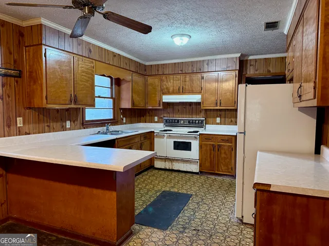 a kitchen with kitchen island a stove a sink and a refrigerator