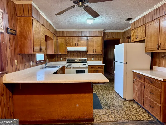 a kitchen with stainless steel appliances granite countertop a refrigerator a stove and a sink