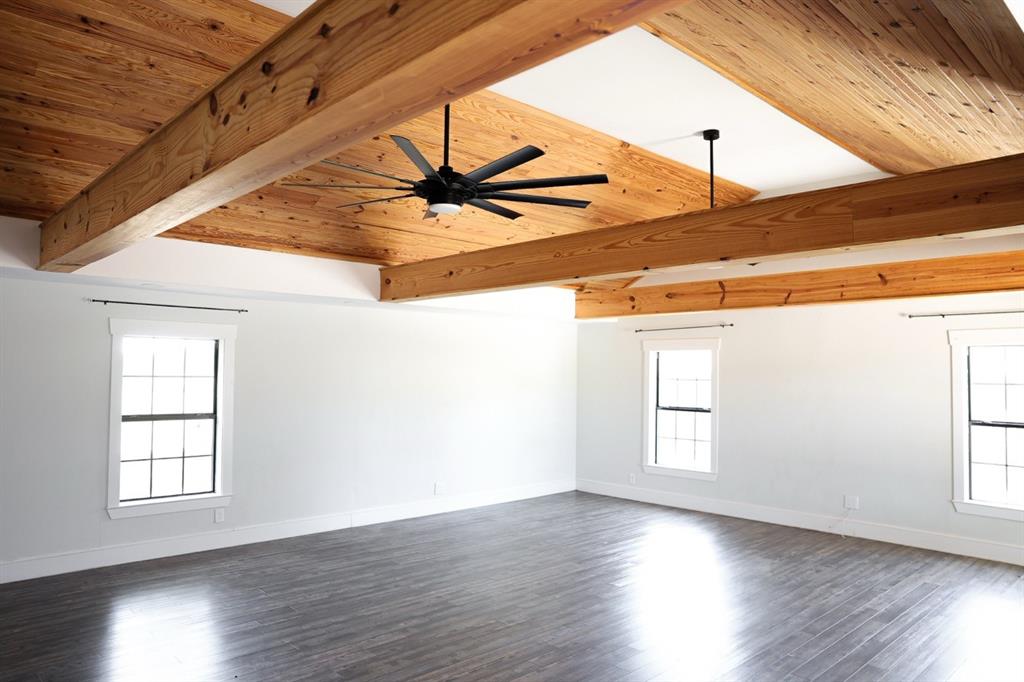 10575 Friendship Road Pilot Point, TX 76258 - Photo 18 of 32 Vaulted wood-plank ceiling with exposed beams and a large ceiling fan