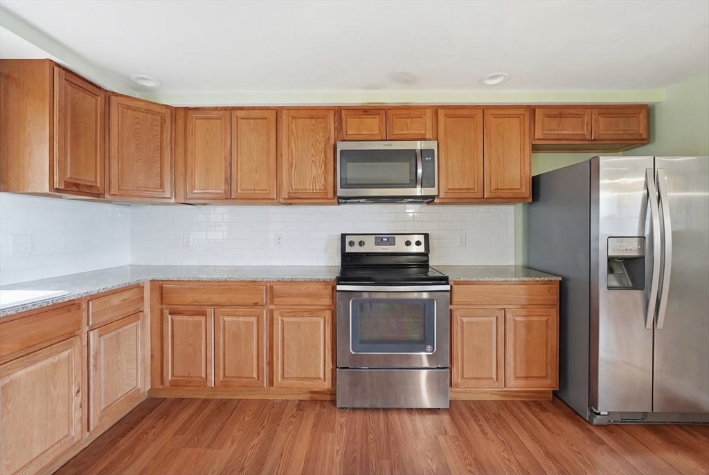 5 Swan Avenue, Unit B Worcester, MA 01602 - Photo 9 of 25 a kitchen with stainless steel appliances granite countertop a refrigerator microwave and sink