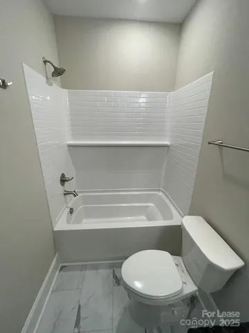 a bathroom with a toilet and a bathtub
