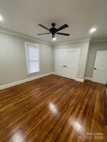 a view of empty room with wooden floor