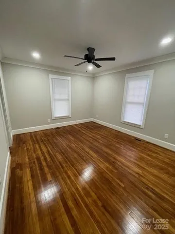 a view of empty room with wooden floor