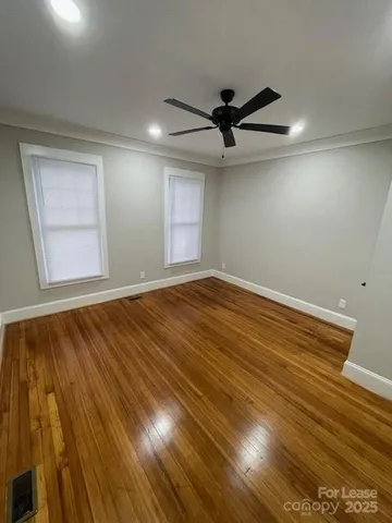 en empty room with wooden floor and windows