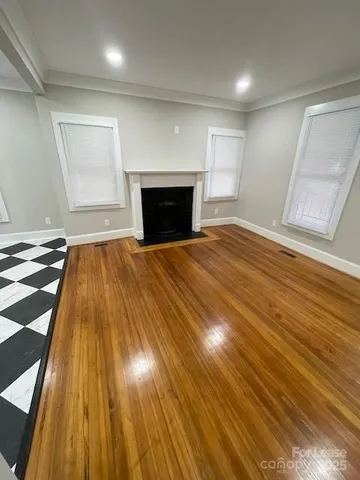 a view of empty room with wooden floor